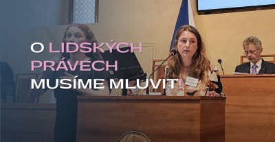 Senátorka Adéla S. Šípová řeční v jednacím sále u řečnického pultu, vedle ní je překladatelka ze znakového jazyka.